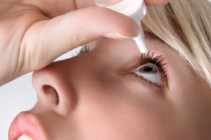 woman applying eyedrops, close up